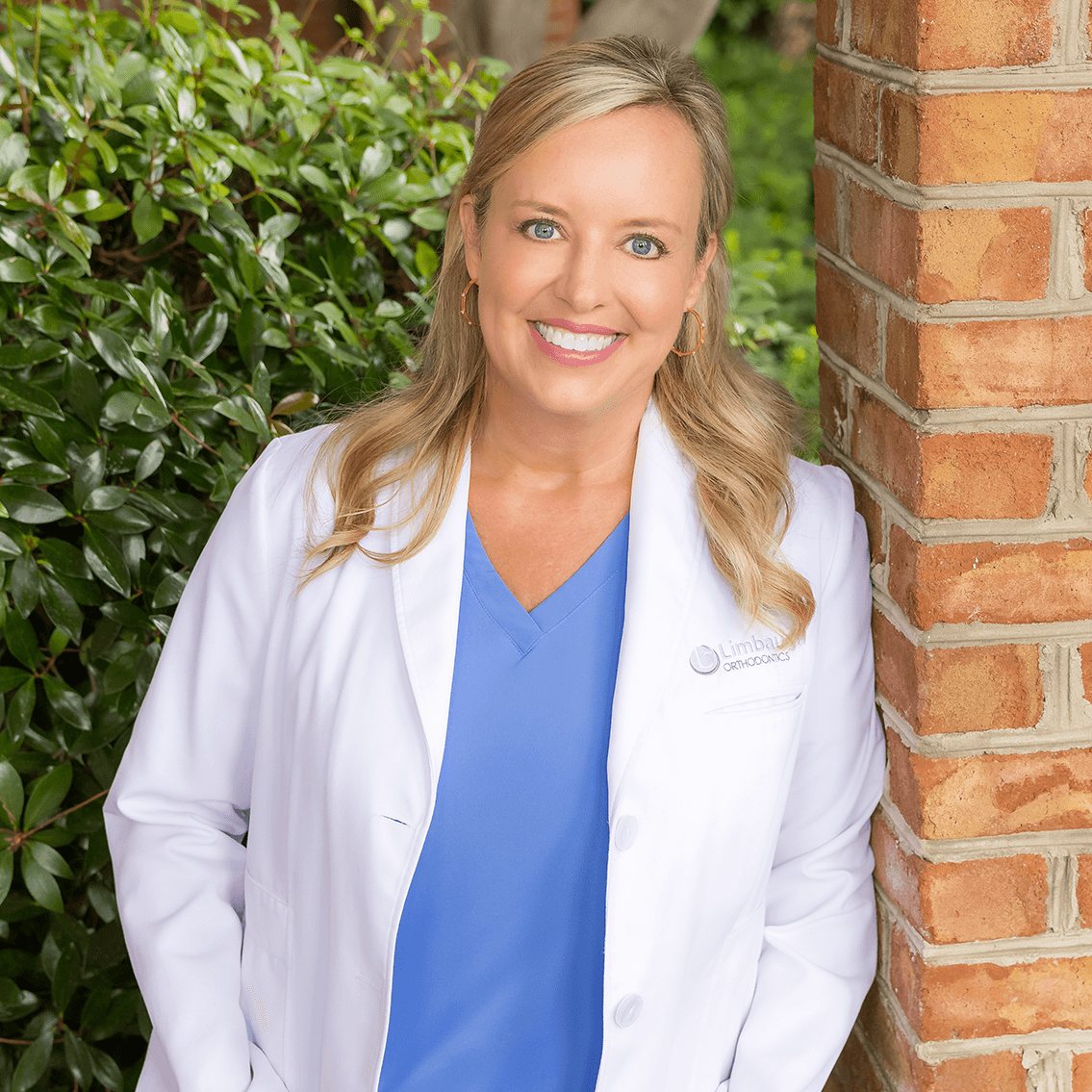 Dr. Lindsay Limbaugh in her white coat outside the Huntsville orthodontic office