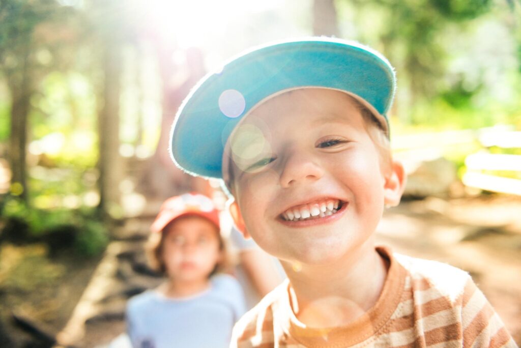 Young child in a cap smiling outdoors