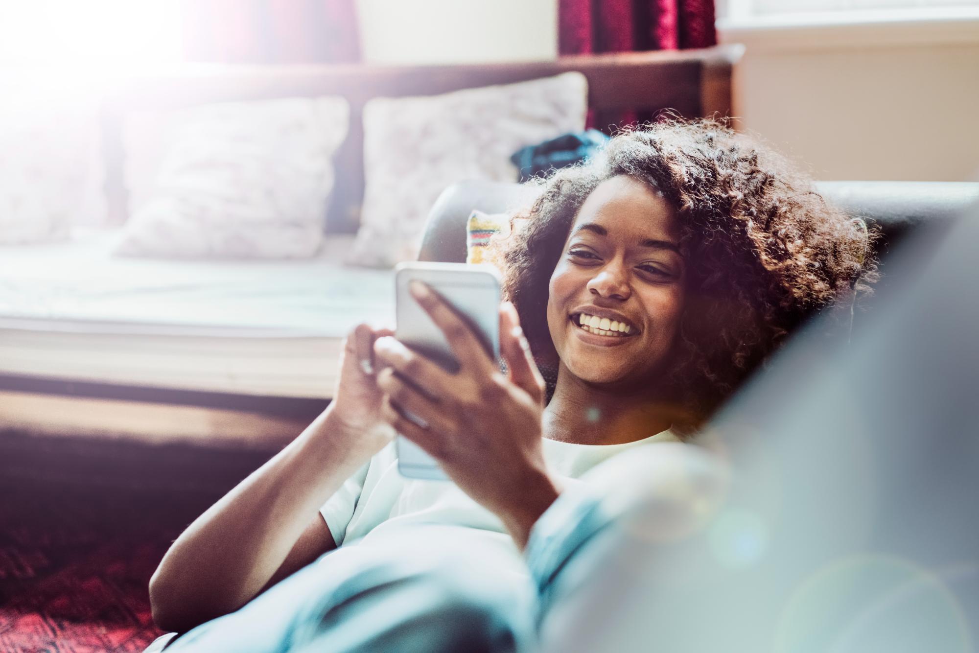Young woman relaxing on a couch with her phone