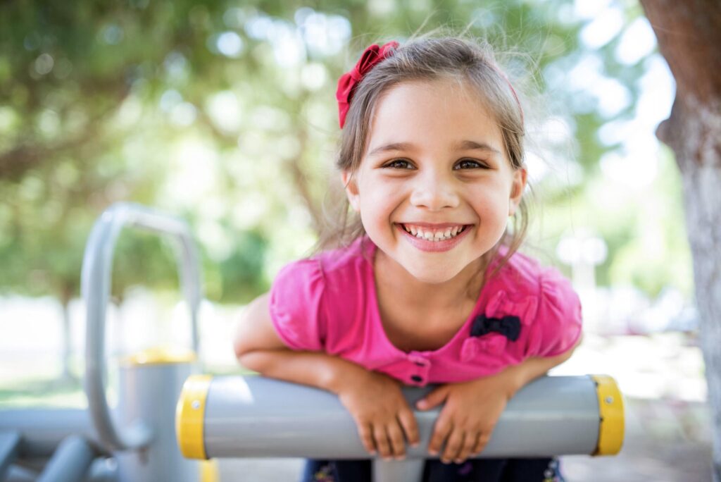 Young girl smiling on playground equipment