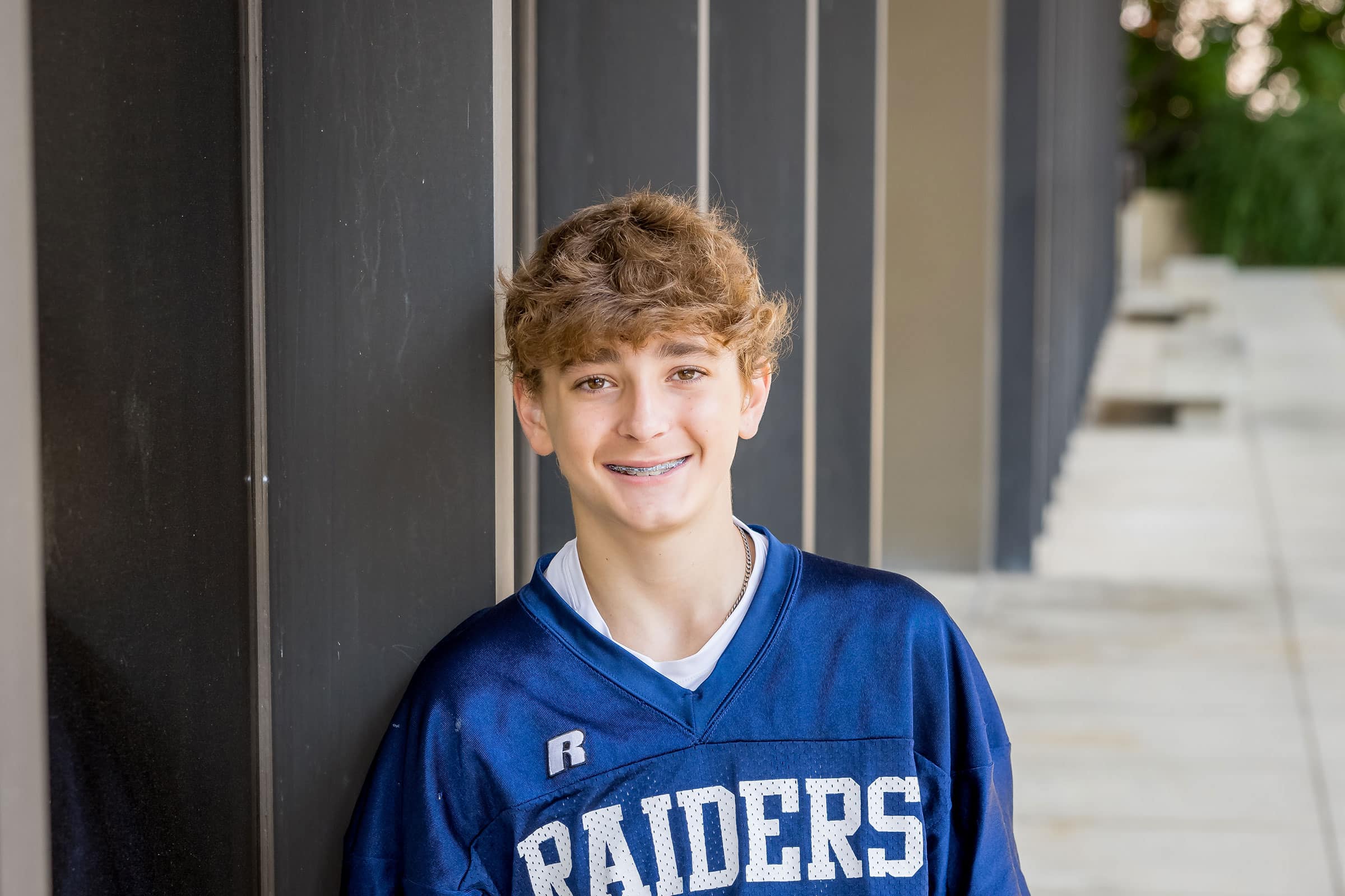 Limbaugh Orthodontics patient in his Raiders jersey smiling outdoors