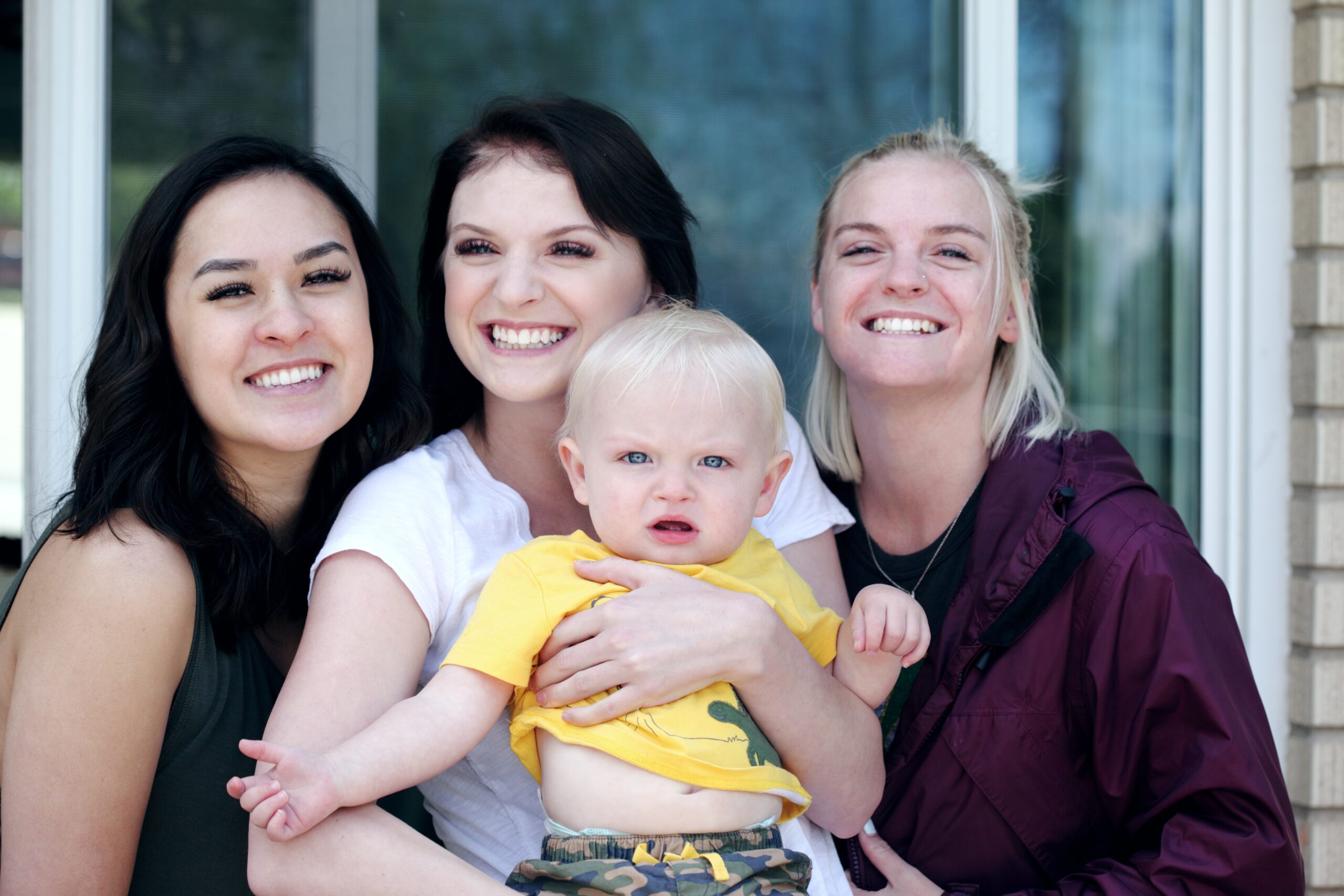 Group of friends smiling together with a baby