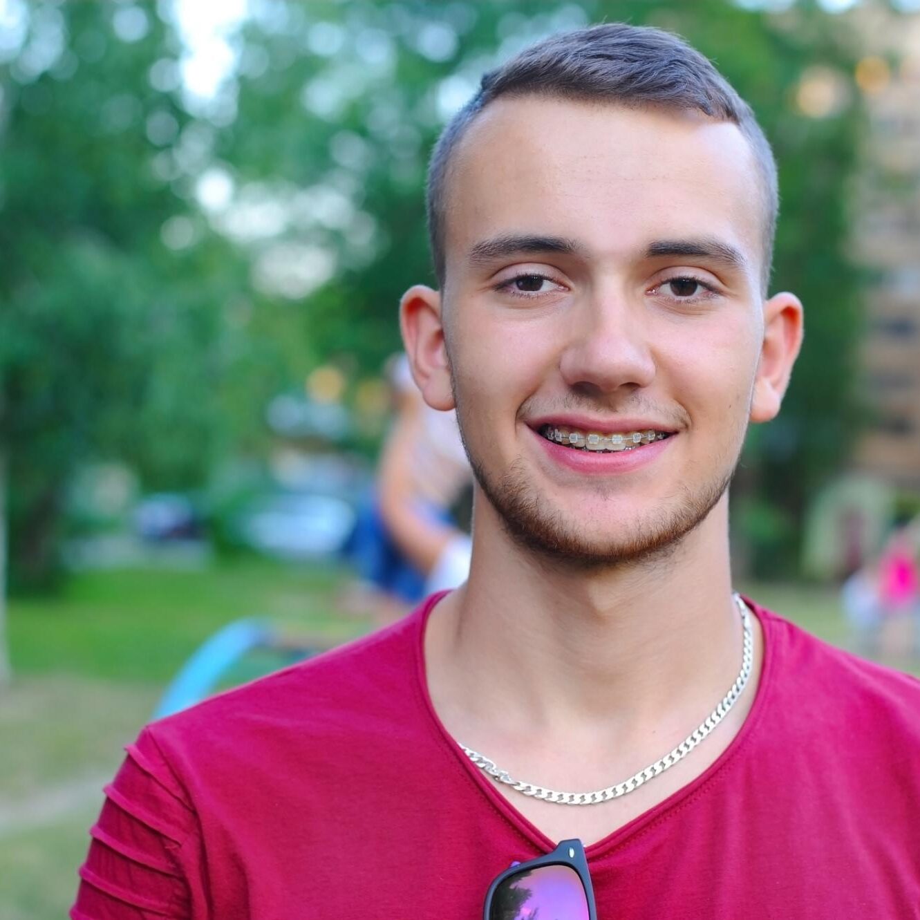 Young man with braces smiling outdoors