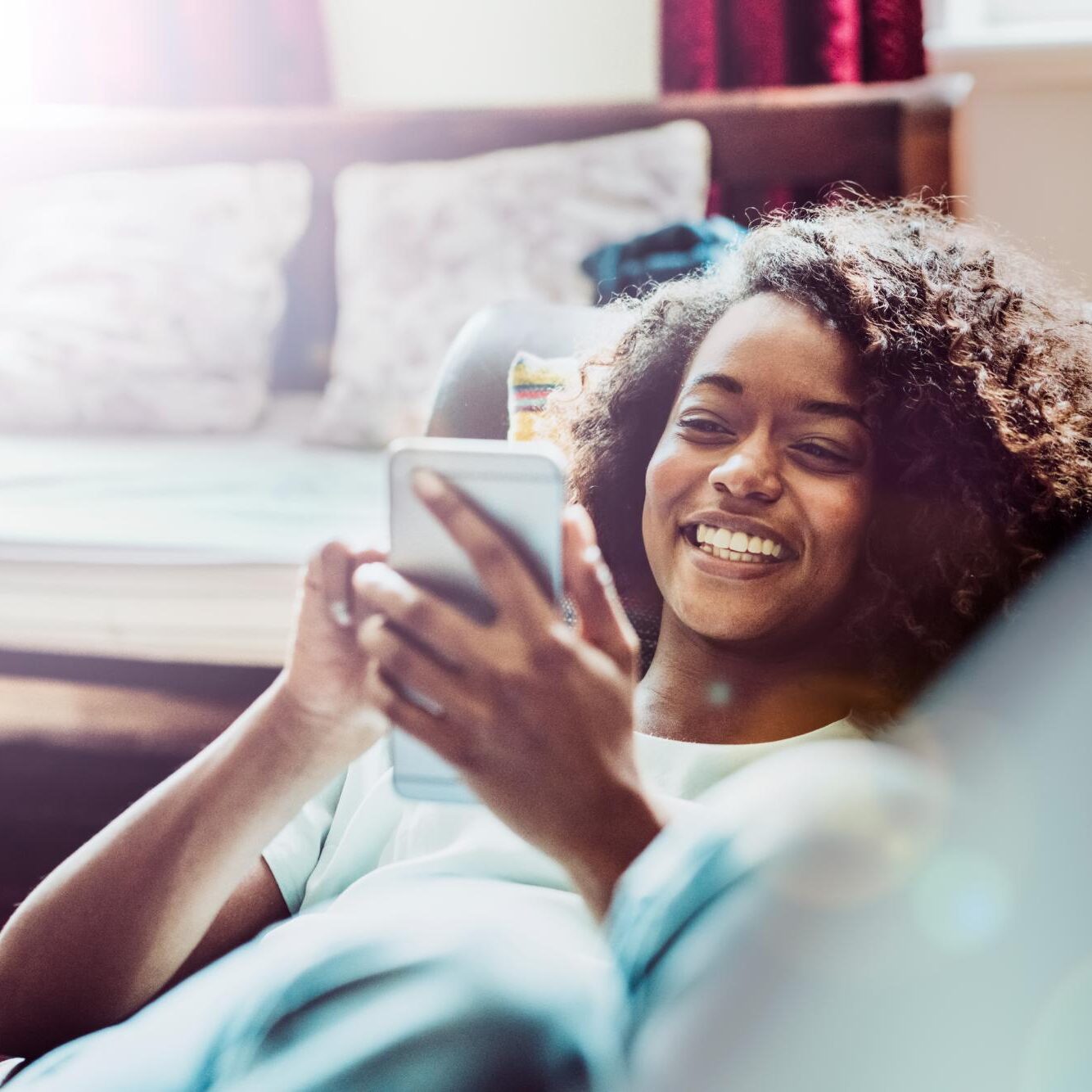 Young woman relaxing on a couch with her phone