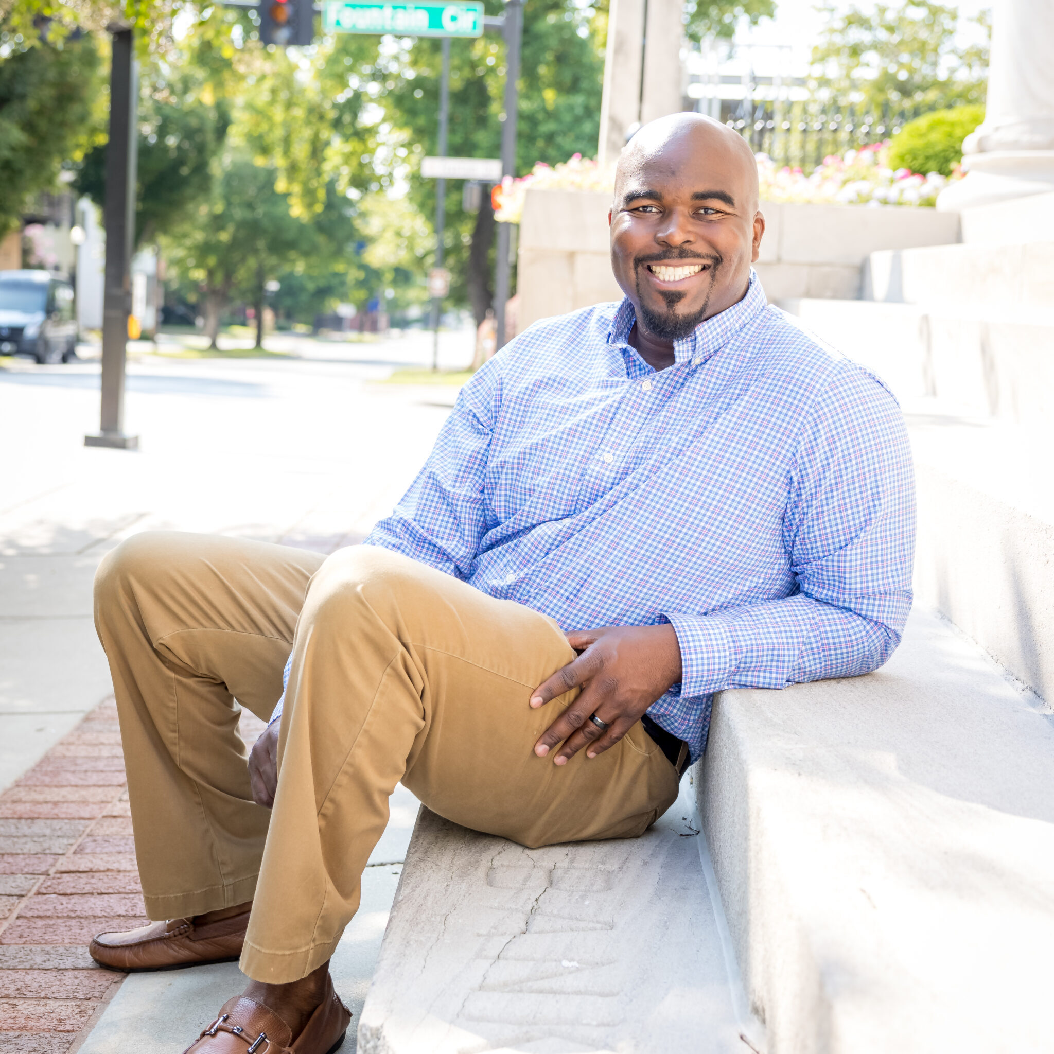 Adult Limbaugh Orthodontics patient smiling on a brick wall downtown