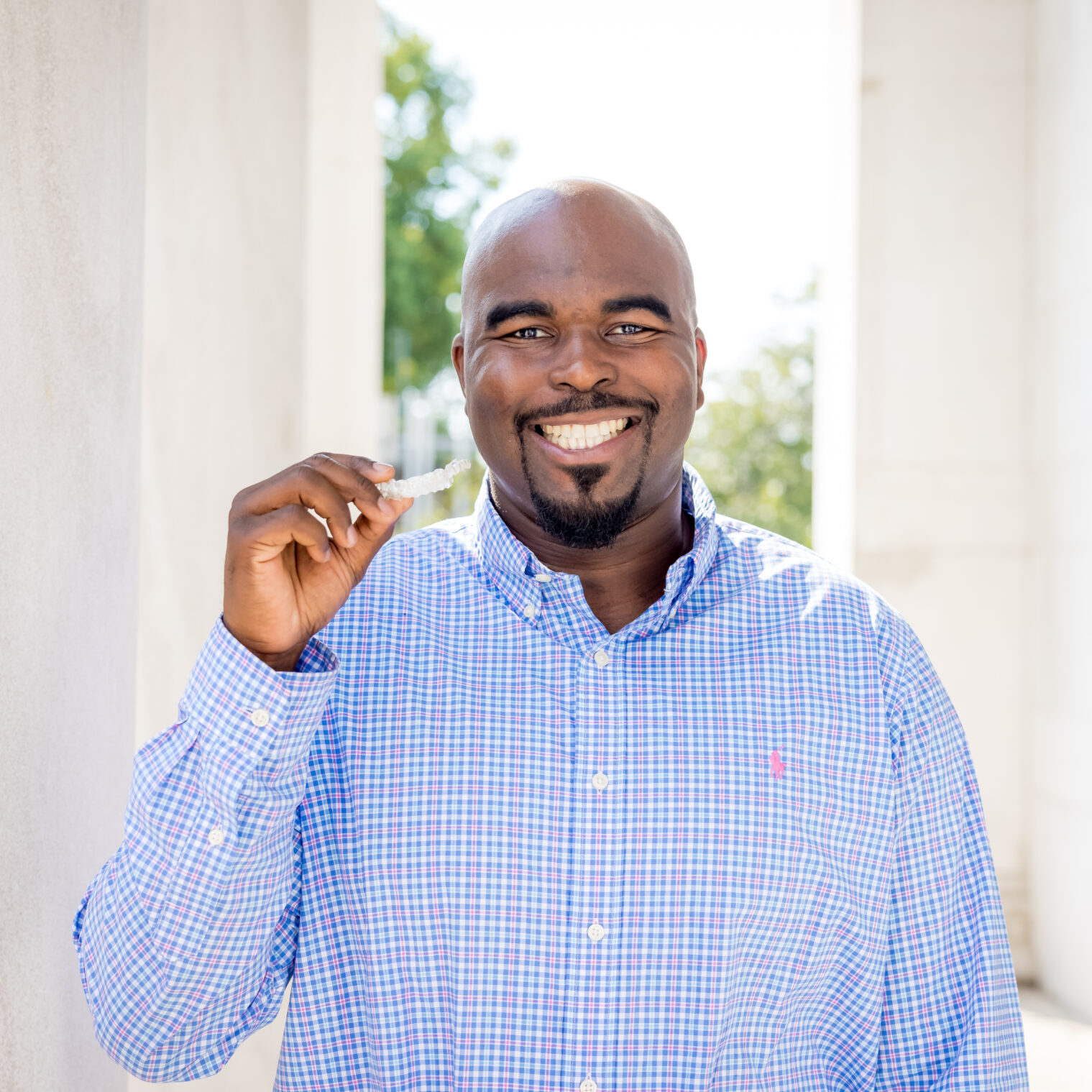 Adult Limbaugh Orthodontics patient smiling with his fist raised