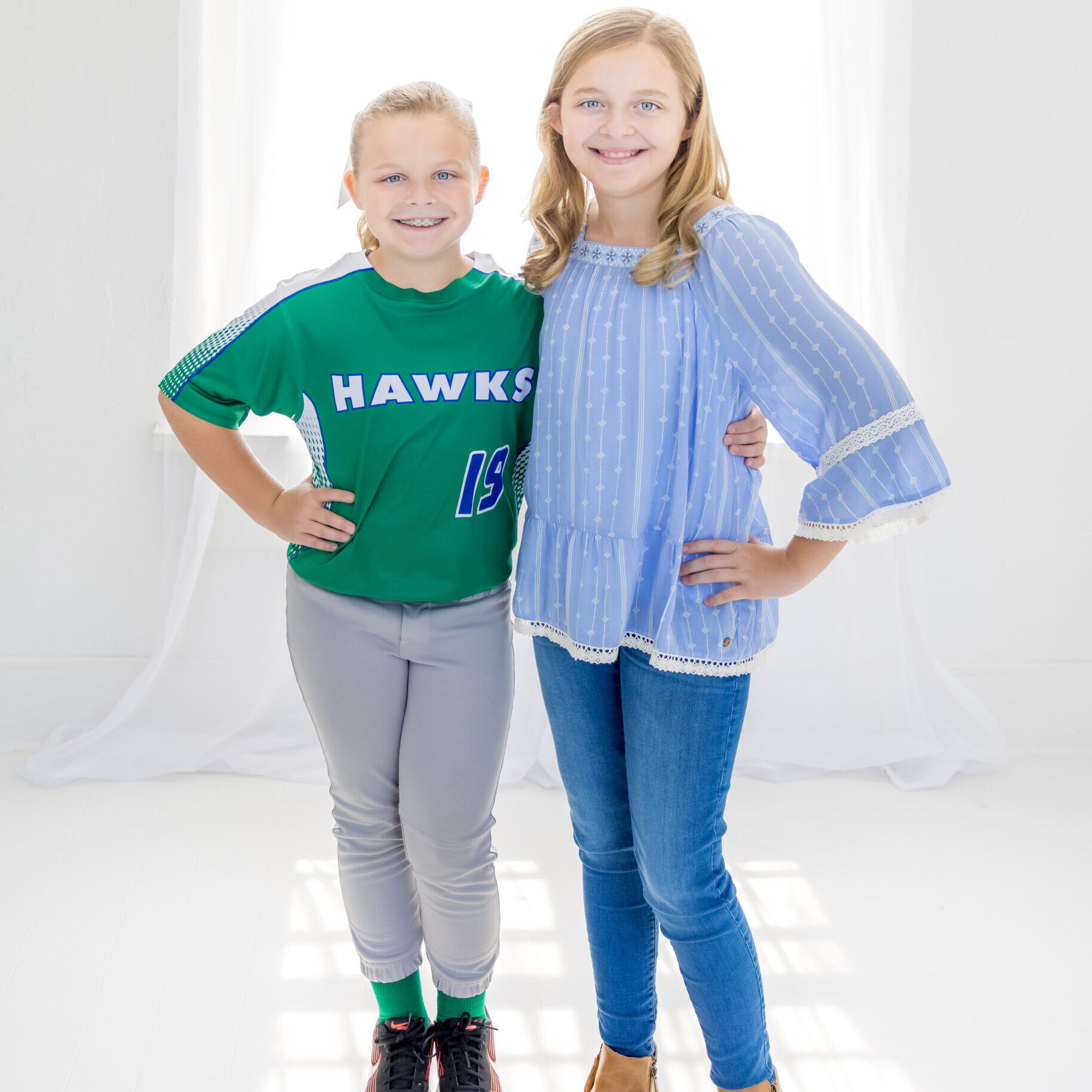 Two young Limbaugh Orthodontics patients smiling side by side
